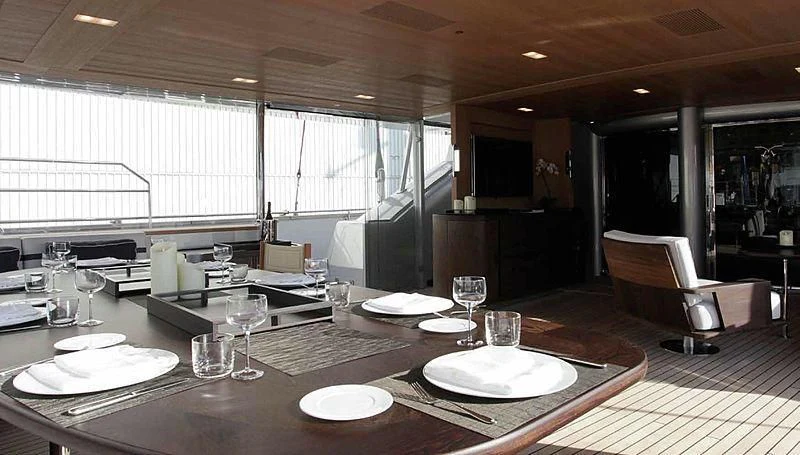 a large dining table with plates and glasses on it aboard SEAHAWK Yacht for Sale