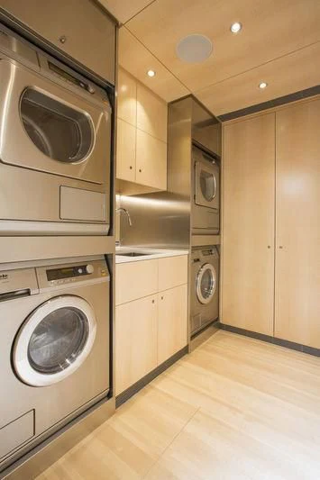 a kitchen with a washing machine and washer aboard UNFURLED Yacht for Sale