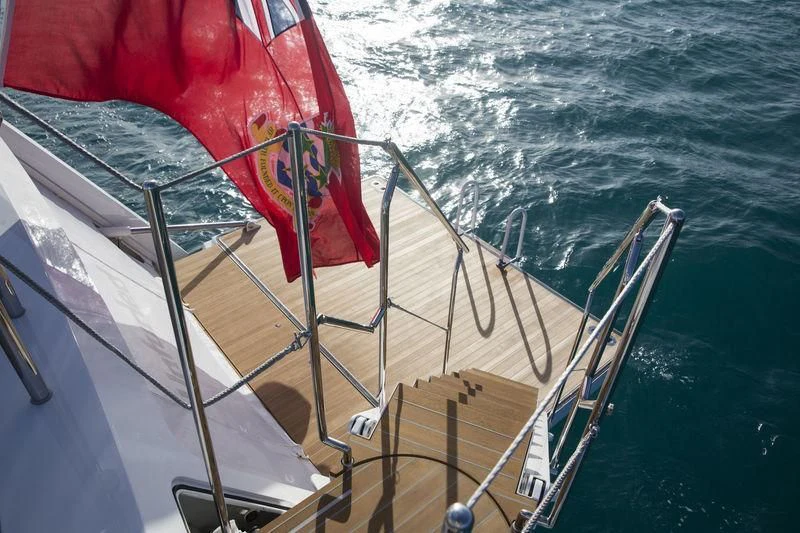 a boat with a flag on the front aboard UNFURLED Yacht for Sale