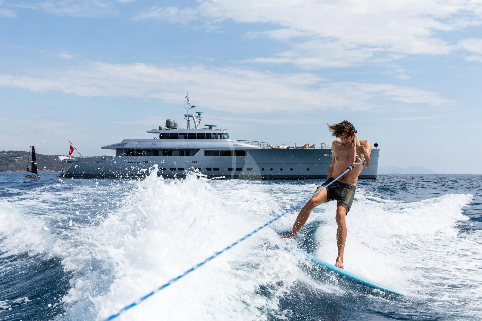 a man surfing on the waves aboard FALCO MOSCATA Yacht for Sale