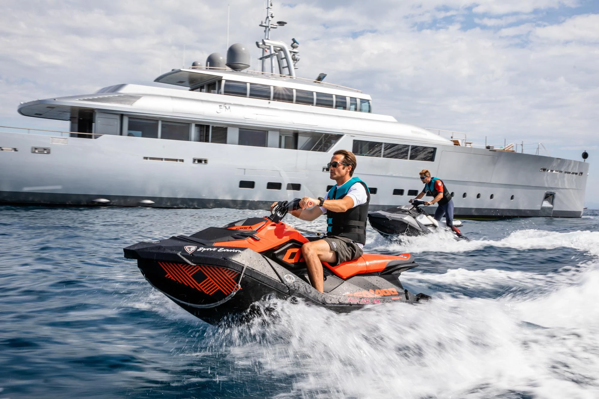 a man on a jet ski in the ocean next to a boat aboard FALCO MOSCATA Yacht for Sale