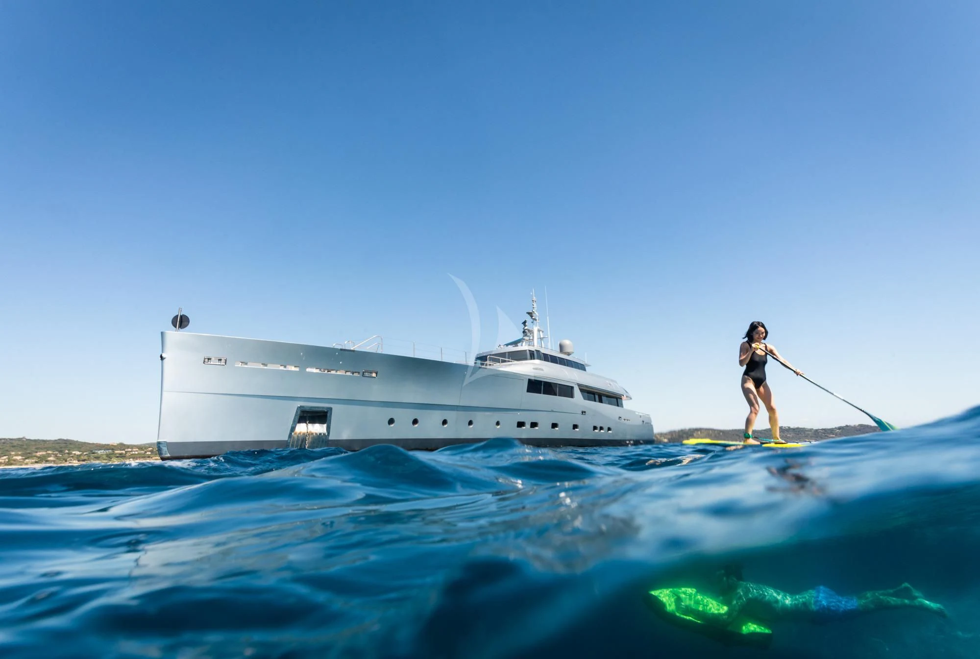 a person on a surfboard next to a boat aboard FALCO MOSCATA Yacht for Sale