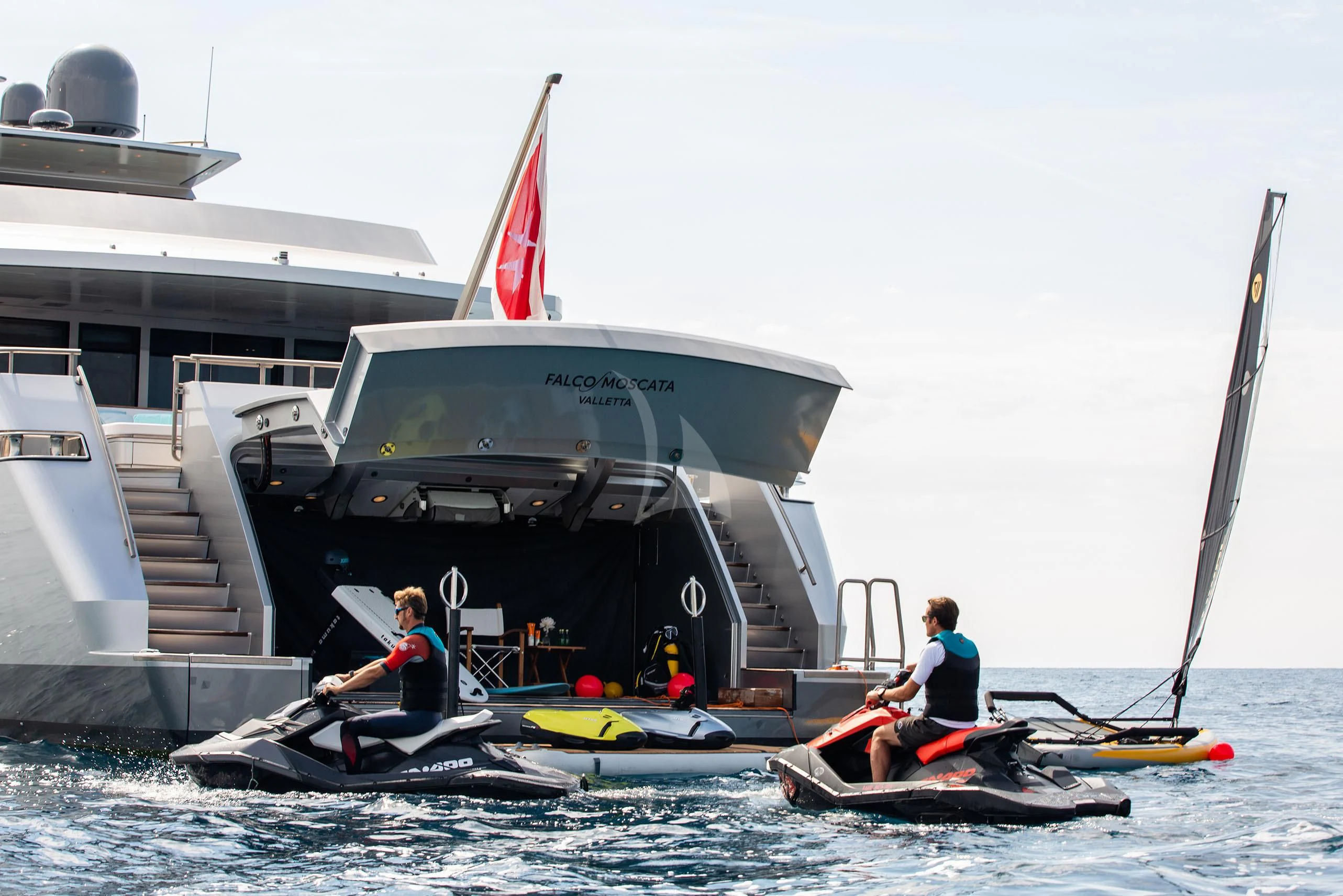 a group of people in kayaks in the water by a boat aboard FALCO MOSCATA Yacht for Sale
