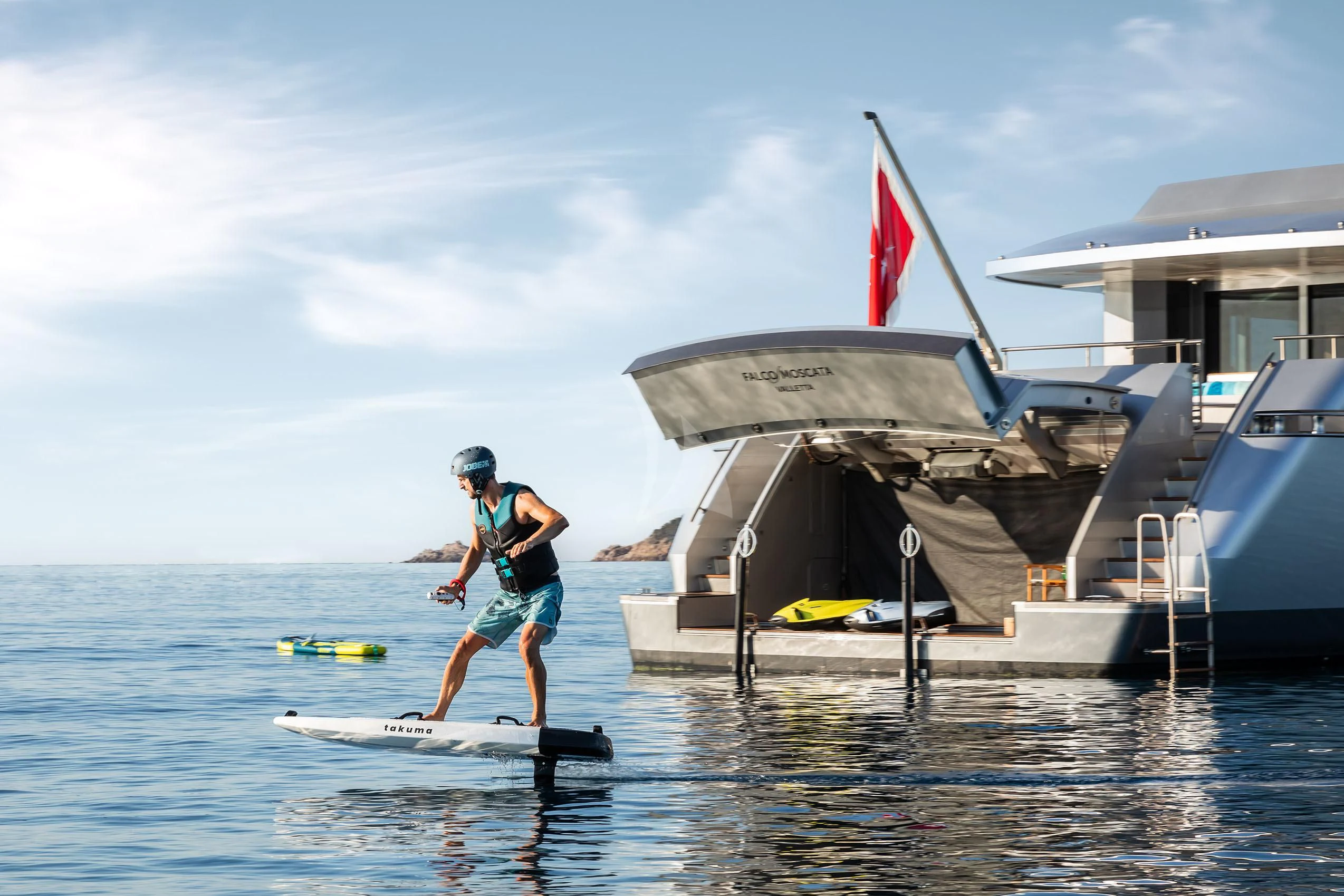 a man riding a surfboard in the water aboard FALCO MOSCATA Yacht for Sale