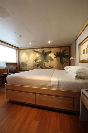a bed with a painting on the wall aboard FALCO MOSCATA Yacht for Sale