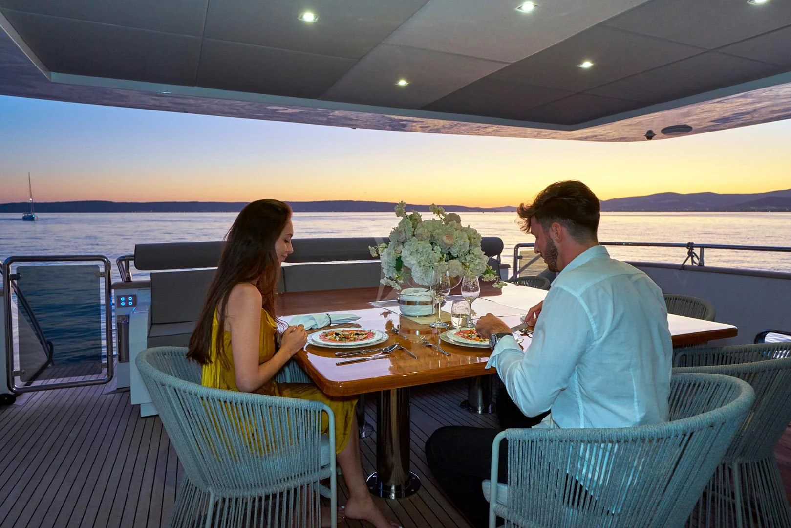a man and woman sitting at a table with food on it aboard PRINCESS LONA Yacht for Sale