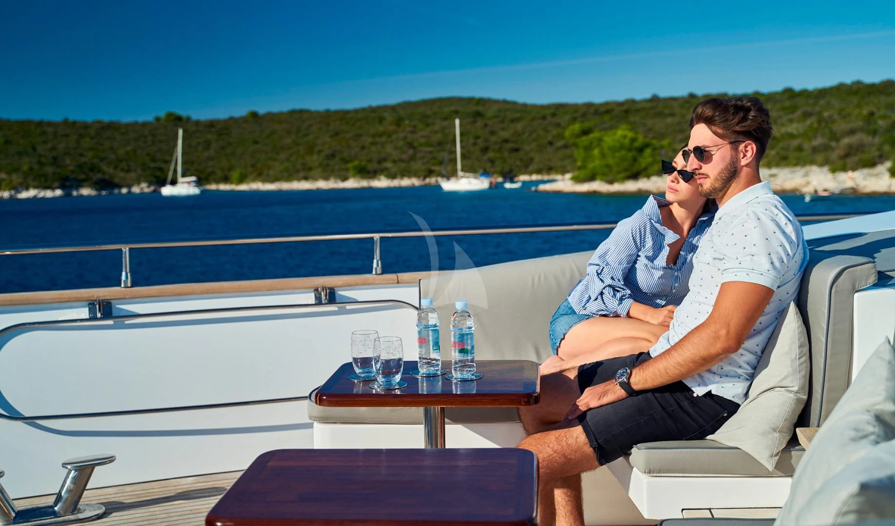 a couple of men sitting on a boat with a view of the water and trees in the background aboard PRINCESS LONA Yacht for Sale