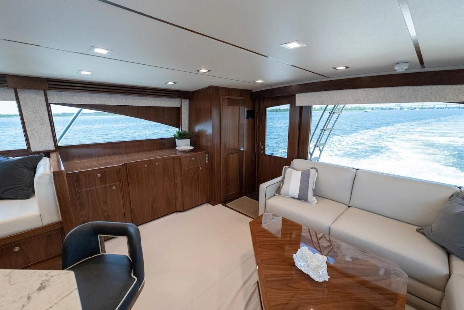a room with a couch and a table and a large window aboard GAME ON Yacht for Sale