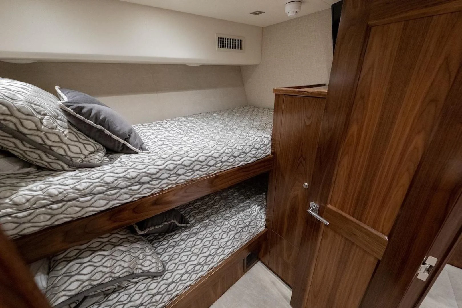 a bed with a wooden headboard aboard GAME ON Yacht for Sale