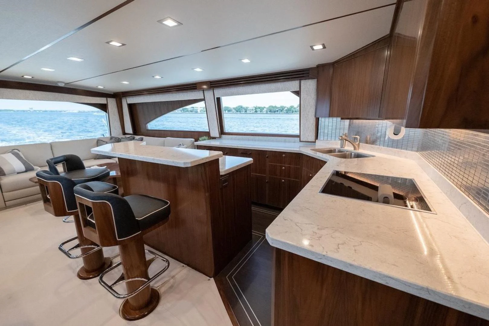 a kitchen with a bar and a table and chairs aboard GAME ON Yacht for Sale