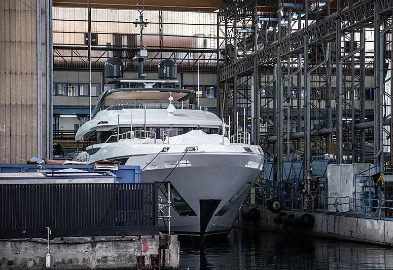 a large white boat sits in a large warehouse aboard DONNA SANTA DUE Yacht for Sale