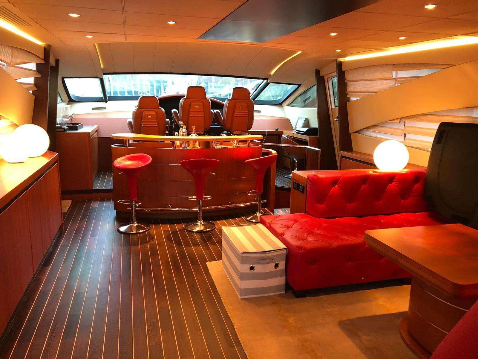 a room with red couches and a table aboard REGAL Yacht for Sale