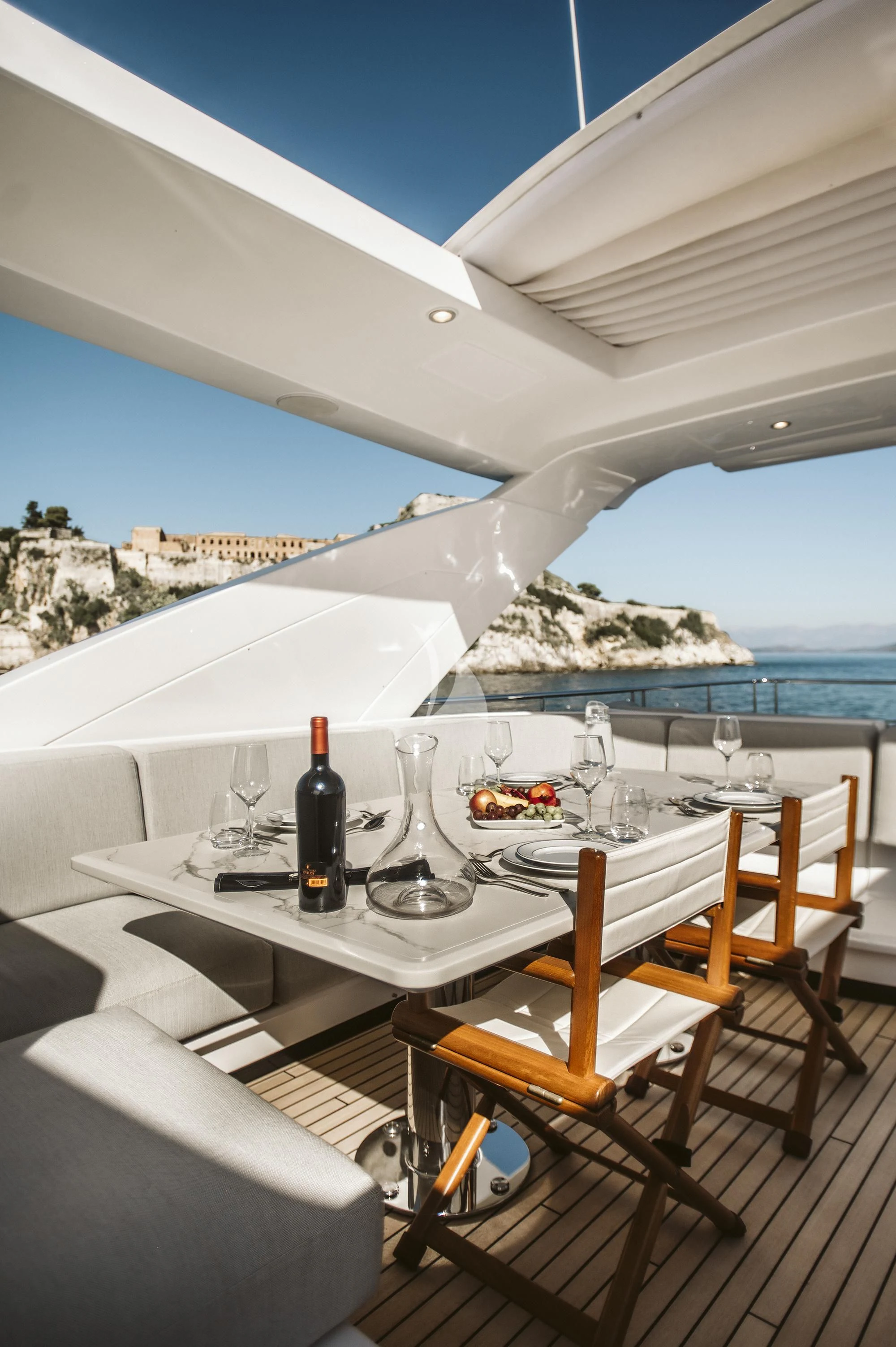 a table with food and wine bottles on it aboard AGIO Yacht for Charter