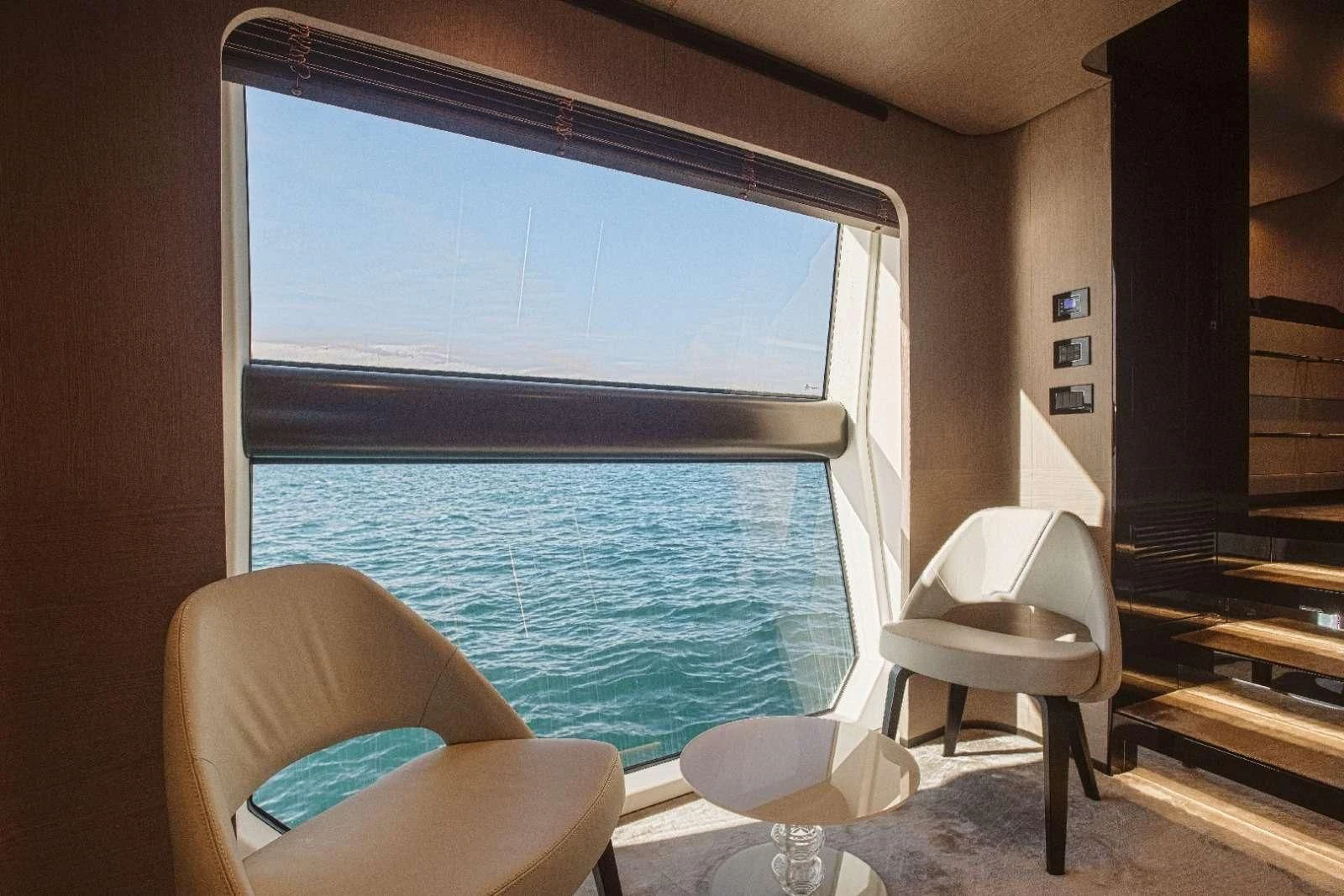 a room with a window and chairs aboard AGIO Yacht for Charter