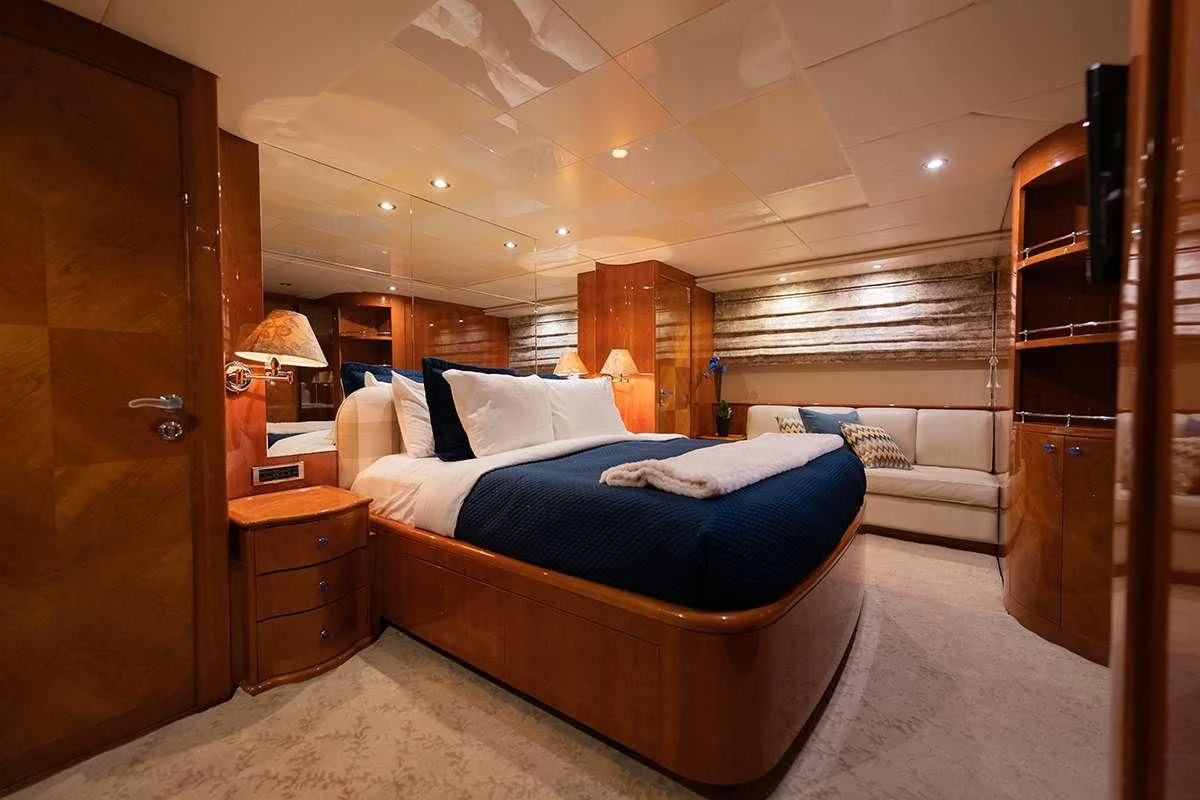 a room with a bed and a dresser aboard ENDLESS SUN Yacht for Sale