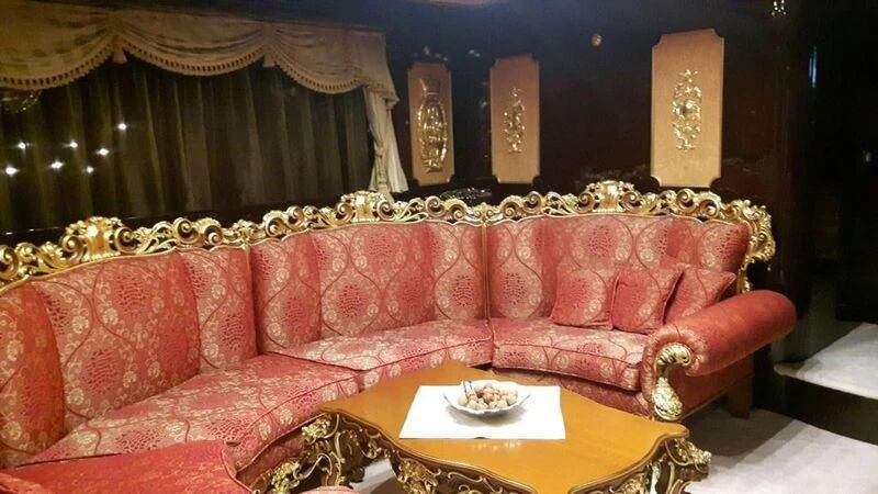 a red couch with a gold table in front of it aboard VISTA II Yacht for Sale