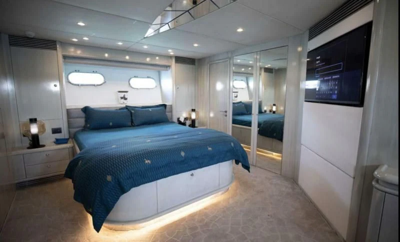 a bedroom with a bed and a tv on the wall aboard UD30 Yacht for Sale