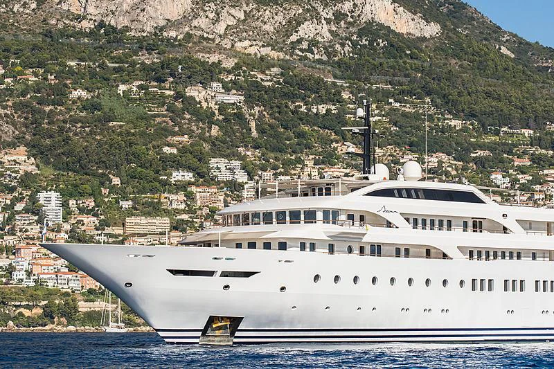 a cruise ship in front of a mountain aboard DREAM Yacht for Sale