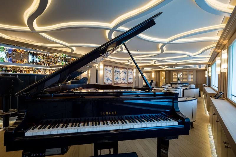 a piano in a room aboard DREAM Yacht for Sale
