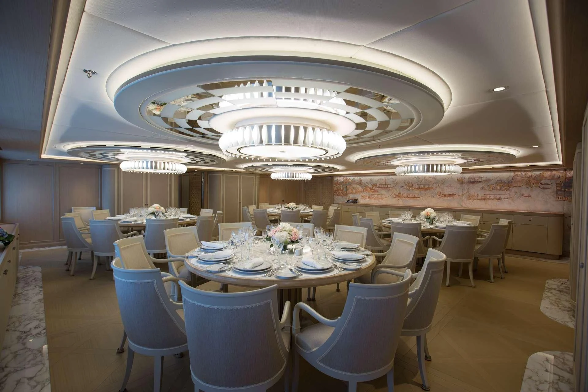 a room with tables and chairs aboard DREAM Yacht for Sale