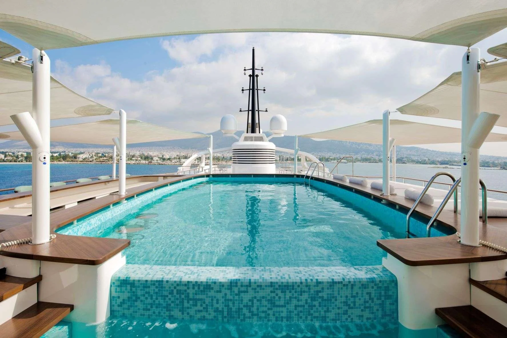 a pool with a large building in the background aboard DREAM Yacht for Sale