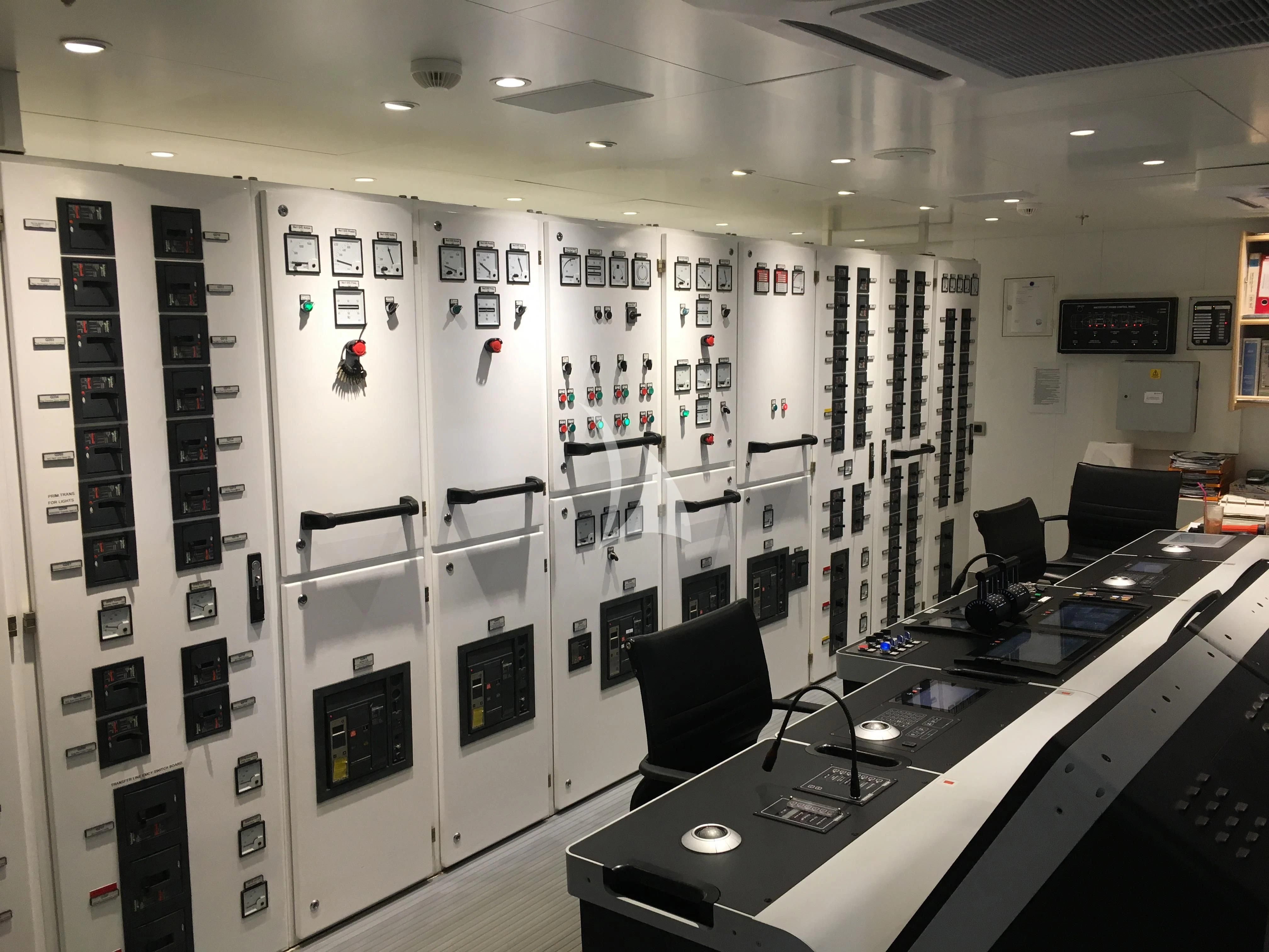 a room with a large display of computer monitors and a chair aboard DREAM Yacht for Sale