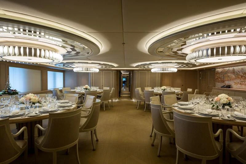 a room with tables and chairs aboard DREAM Yacht for Sale