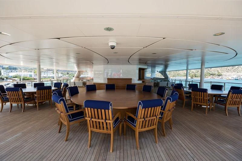 a room with tables and chairs aboard DREAM Yacht for Sale