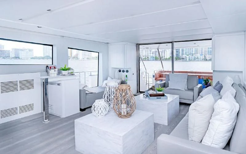 a living room with white furniture aboard JACRU Yacht for Sale
