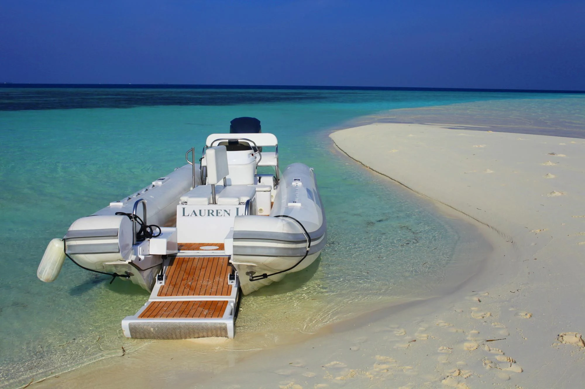 a white boat on a beach aboard LAUREN L Yacht for Sale