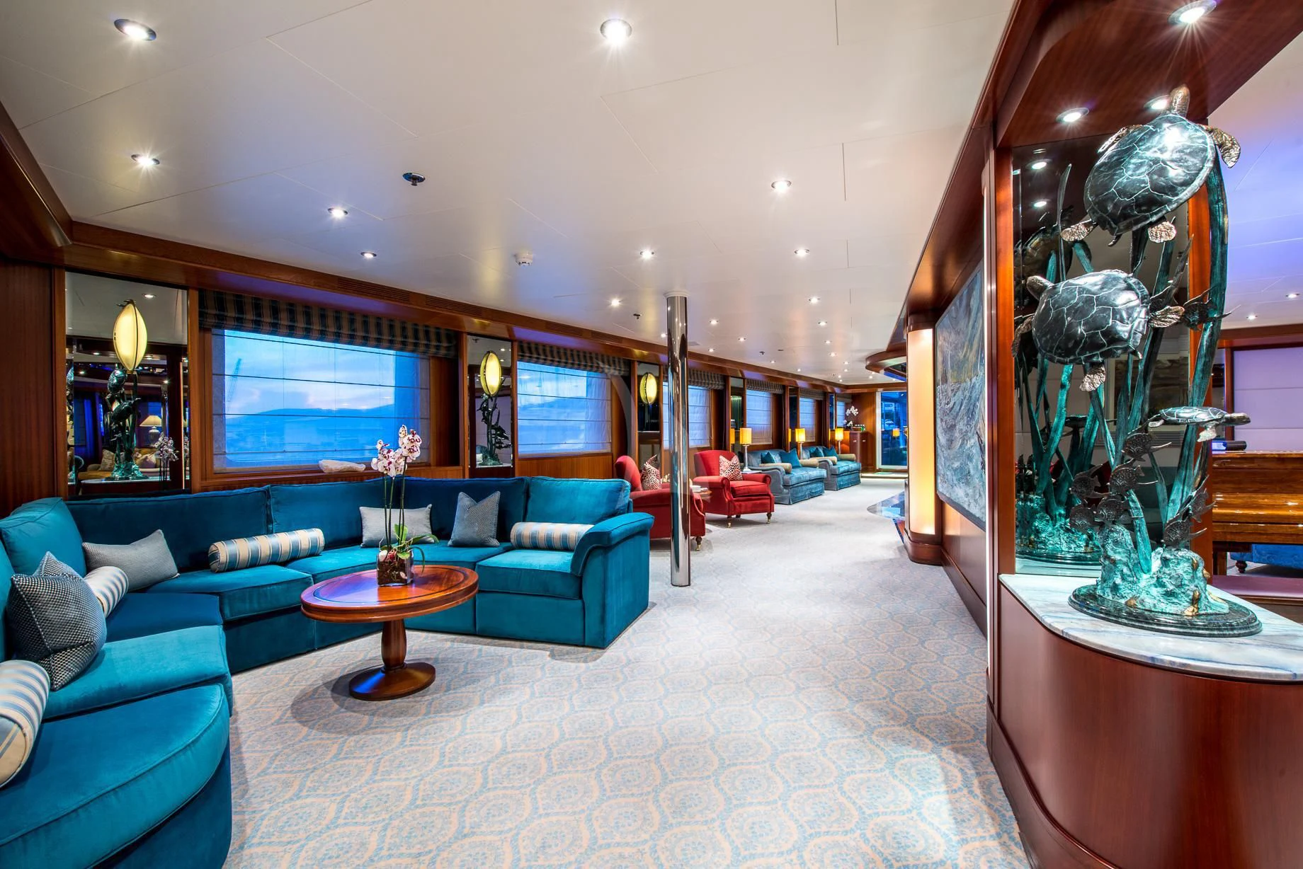 a living room with a blue couch and a large mirror aboard LAUREN L Yacht for Sale