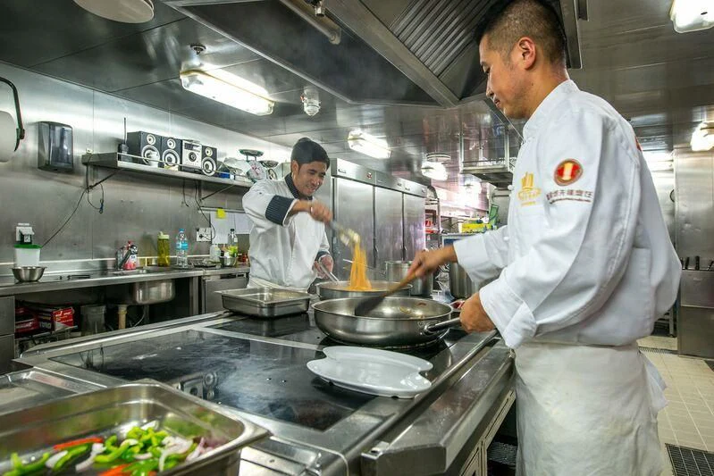 a couple of chefs in a kitchen aboard LAUREN L Yacht for Sale