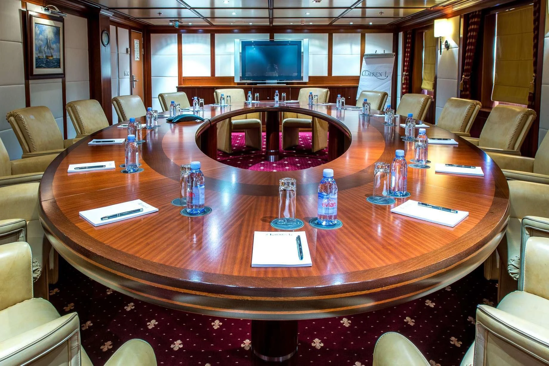 a table with chairs and a television on it aboard LAUREN L Yacht for Sale