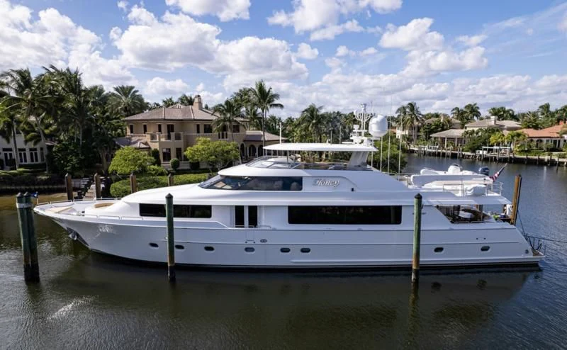 a white yacht in a harbor aboard SYMPHONY Yacht for Sale