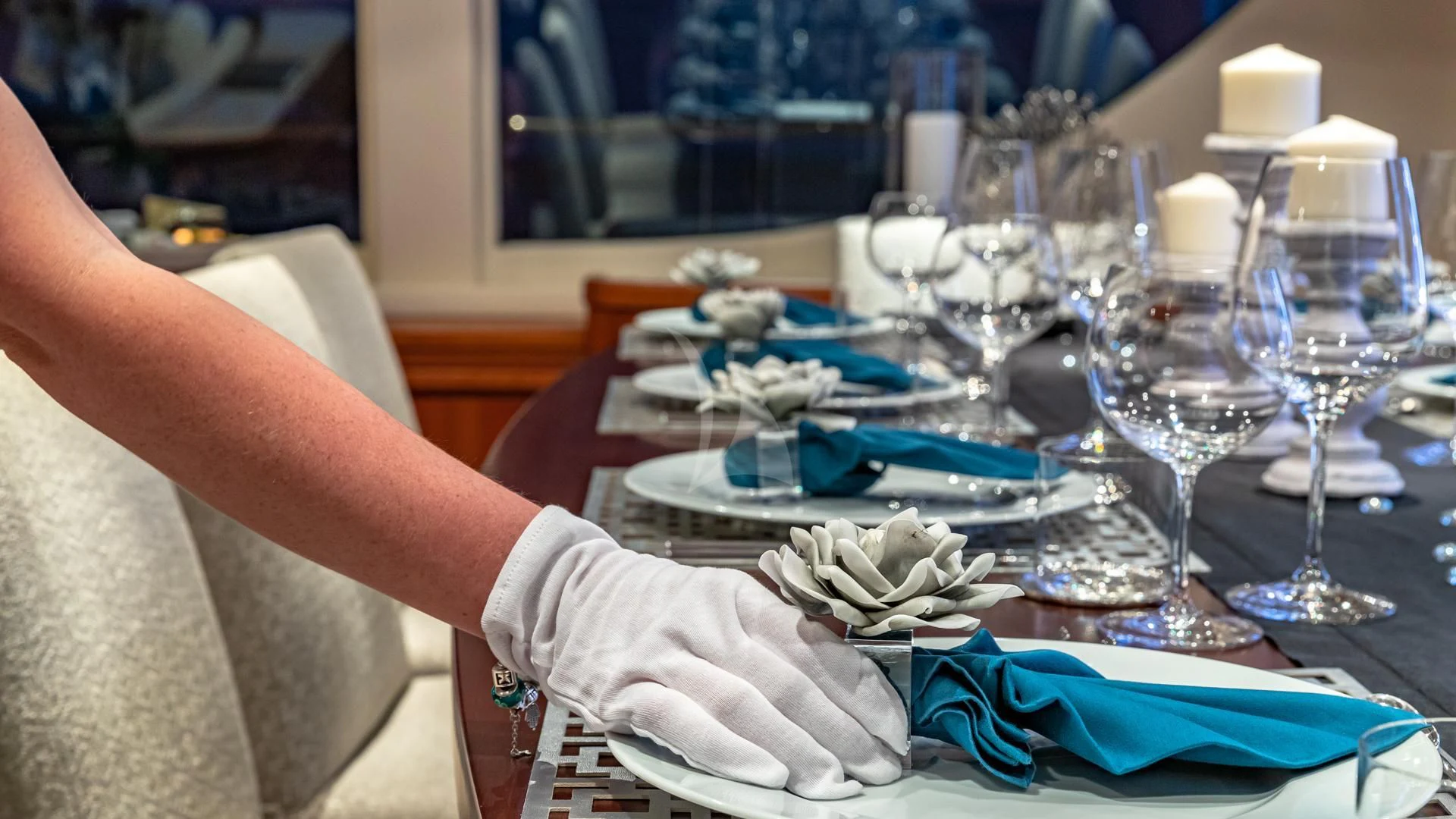 a person's hand holding a napkin over a table with food and glasses on it aboard SWEET EMOCEAN Yacht for Sale