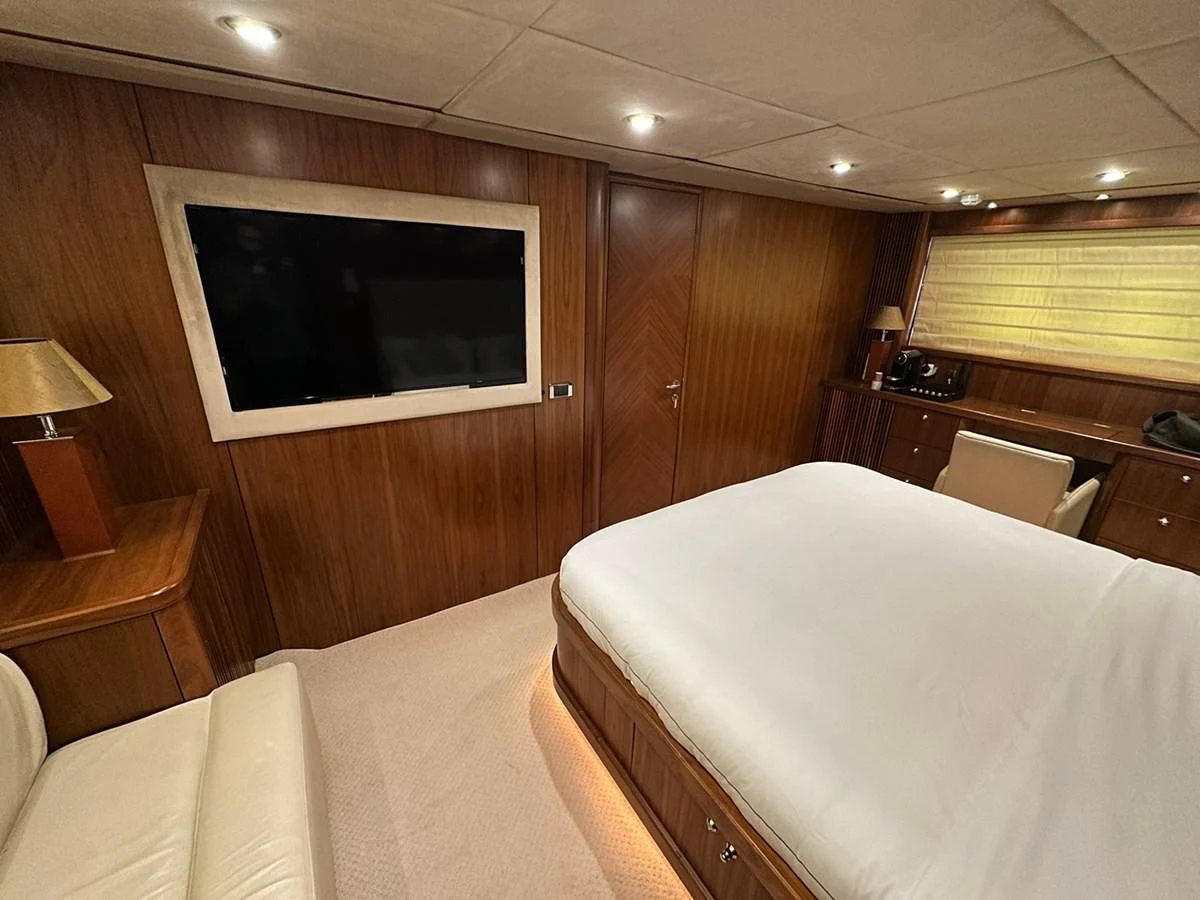 a room with a bed and a television aboard MILA DUBAI Yacht for Sale