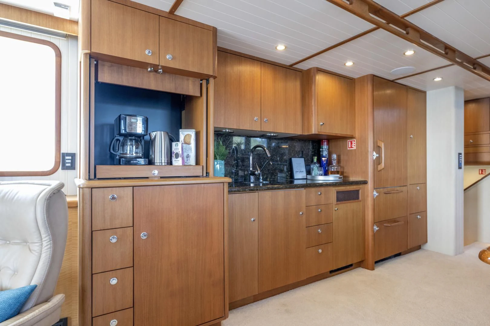 a kitchen with wooden cabinets aboard CHEEMAUN Yacht for Sale