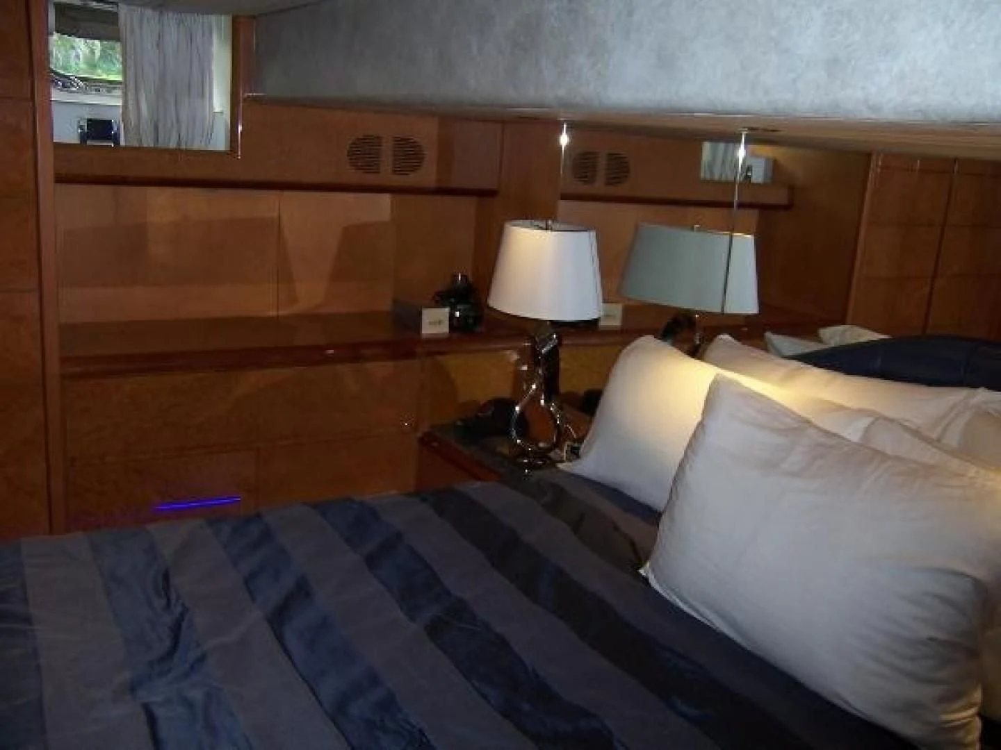 a bed with a lamp on it aboard UNZIPPED Yacht for Sale