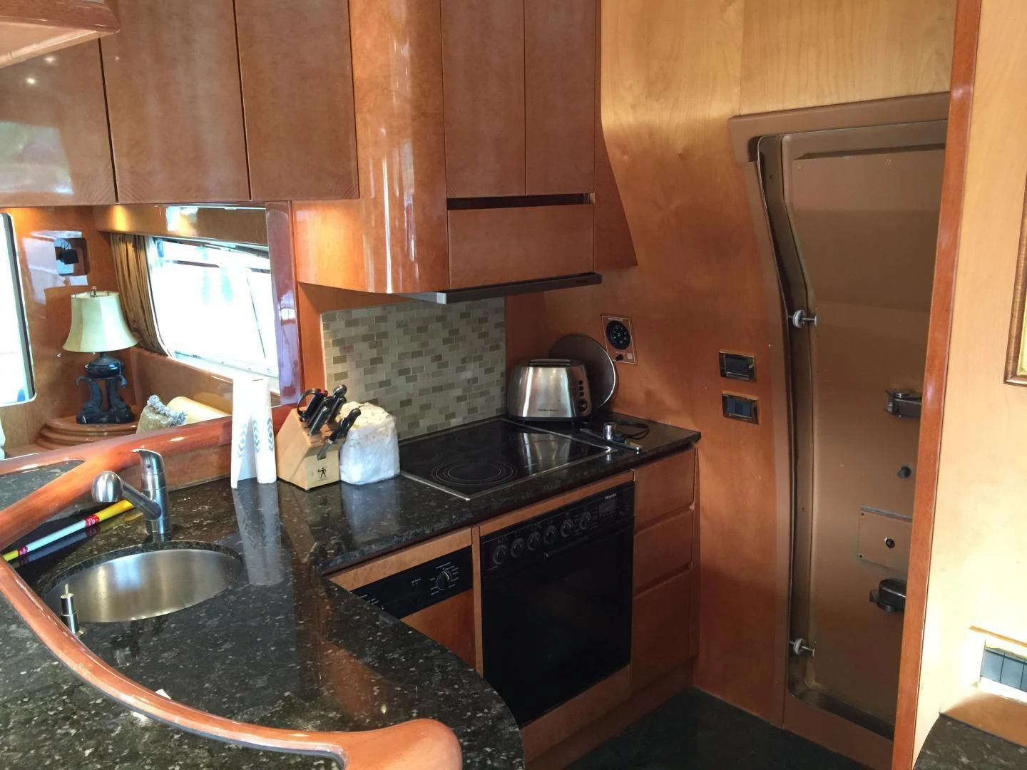 a kitchen with wooden cabinets aboard UNZIPPED Yacht for Sale