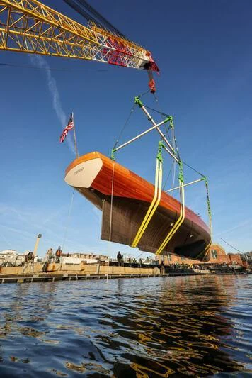 a yellow and red boat on a body of water aboard CORONET Yacht for Sale