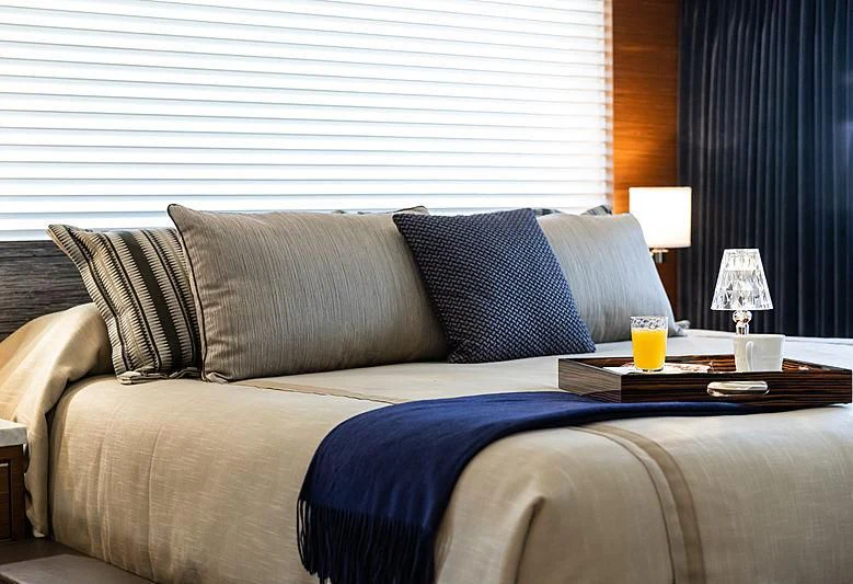 a bed with pillows and a coffee table aboard NORTHLAND Yacht for Sale