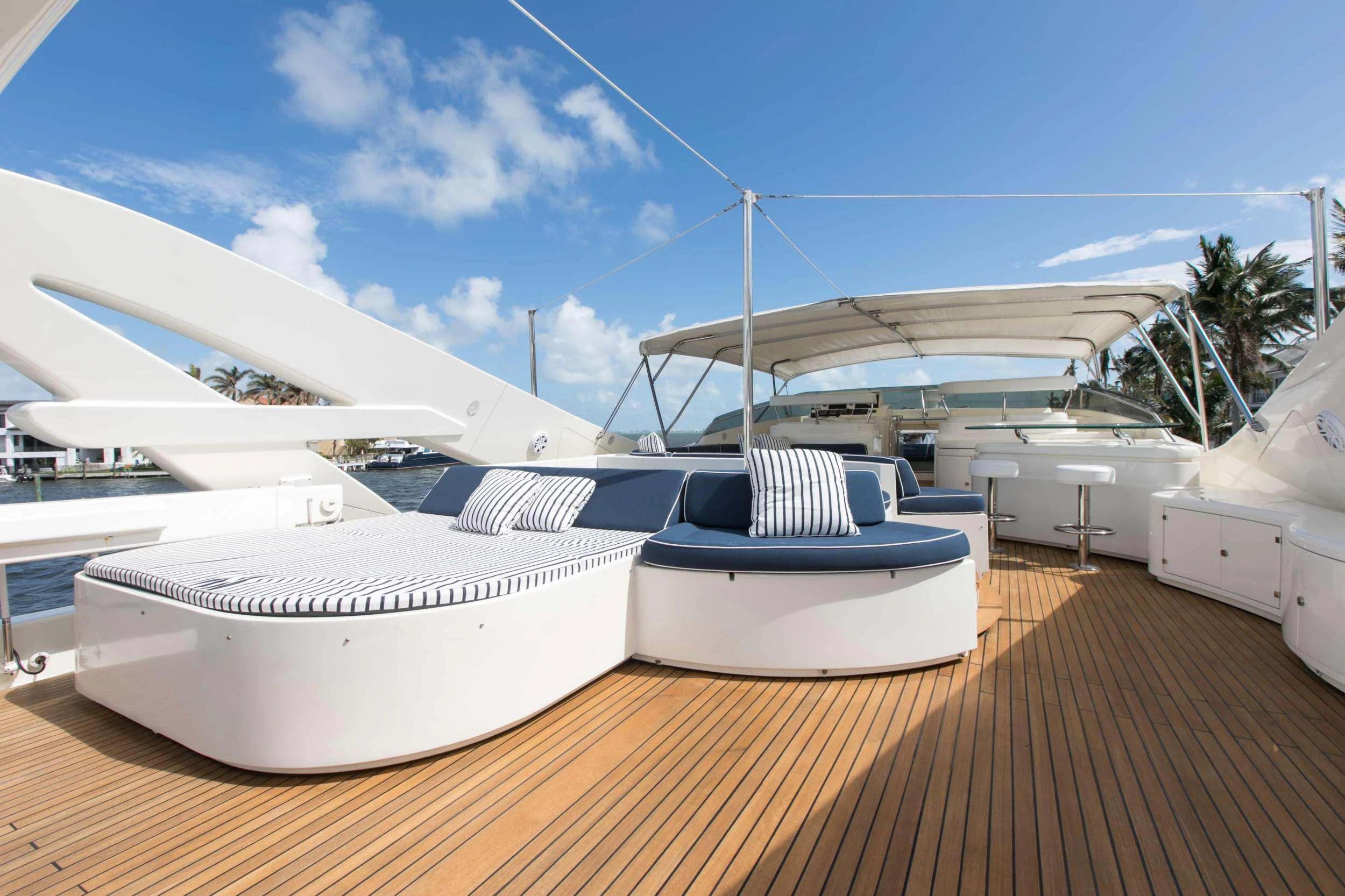a deck with a row of white yachts and a white building with a white roof and blue aboard MAMBO Yacht for Sale