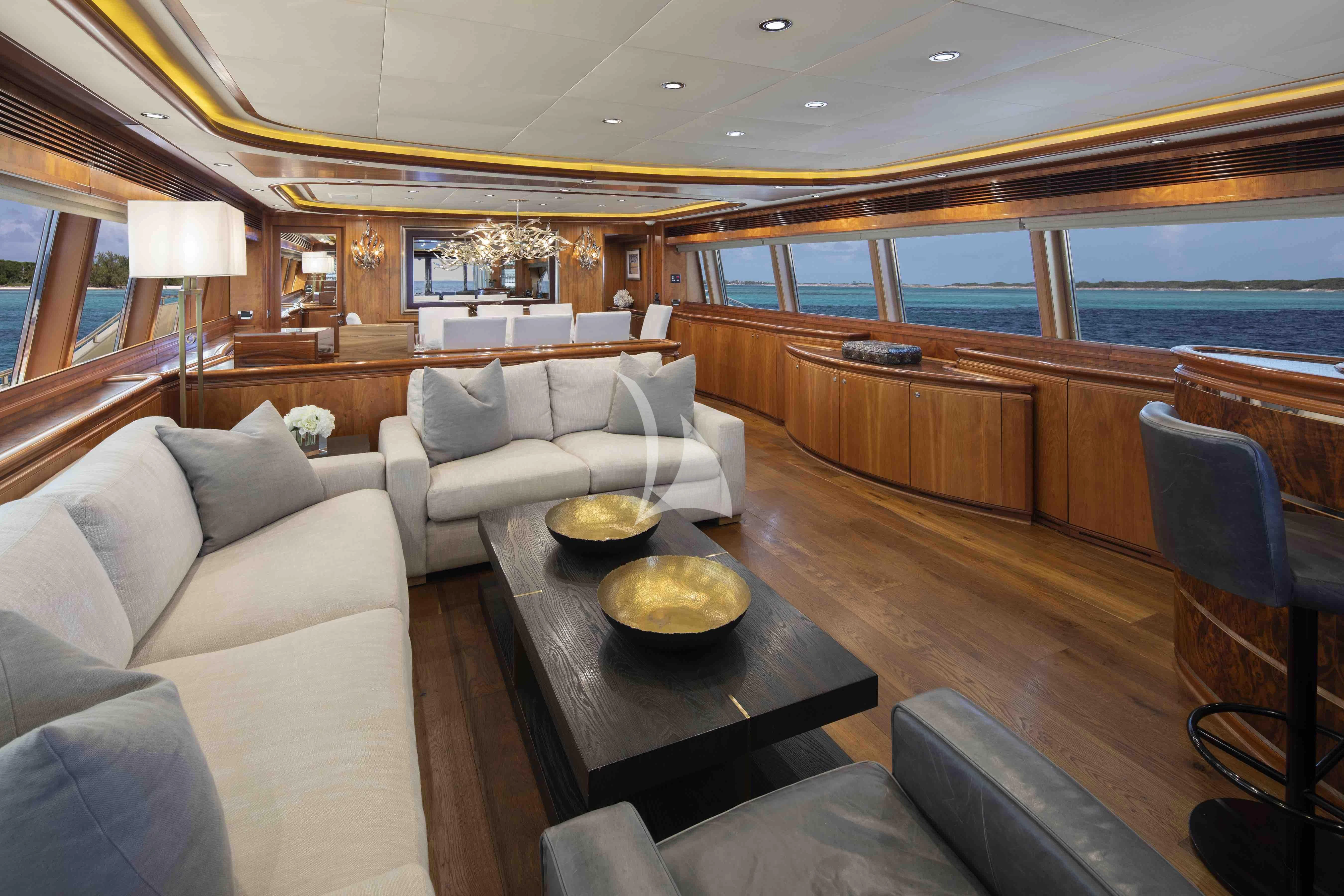 a living room with a large wood table and a large window aboard MAMBO Yacht for Sale
