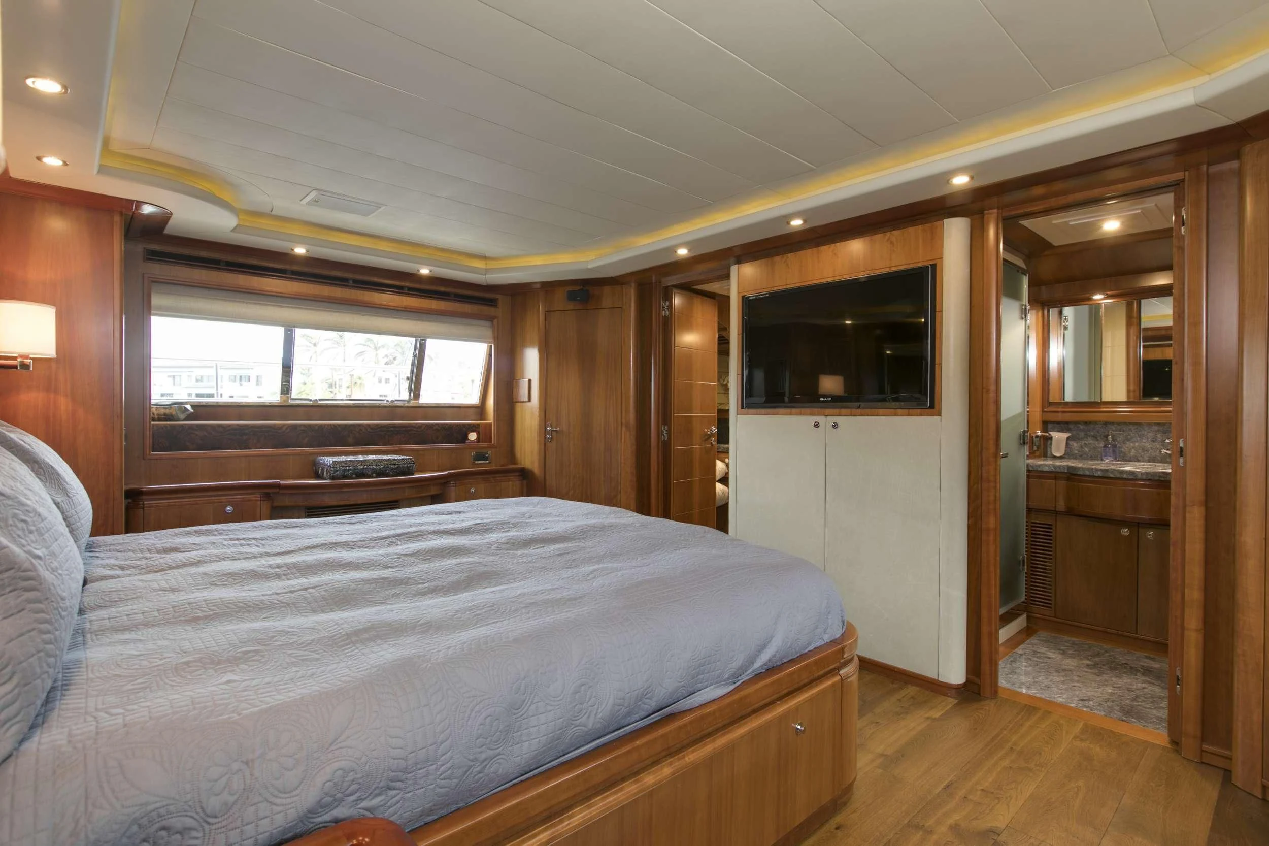 a bedroom with a bed and a wood cabinet aboard MAMBO Yacht for Sale