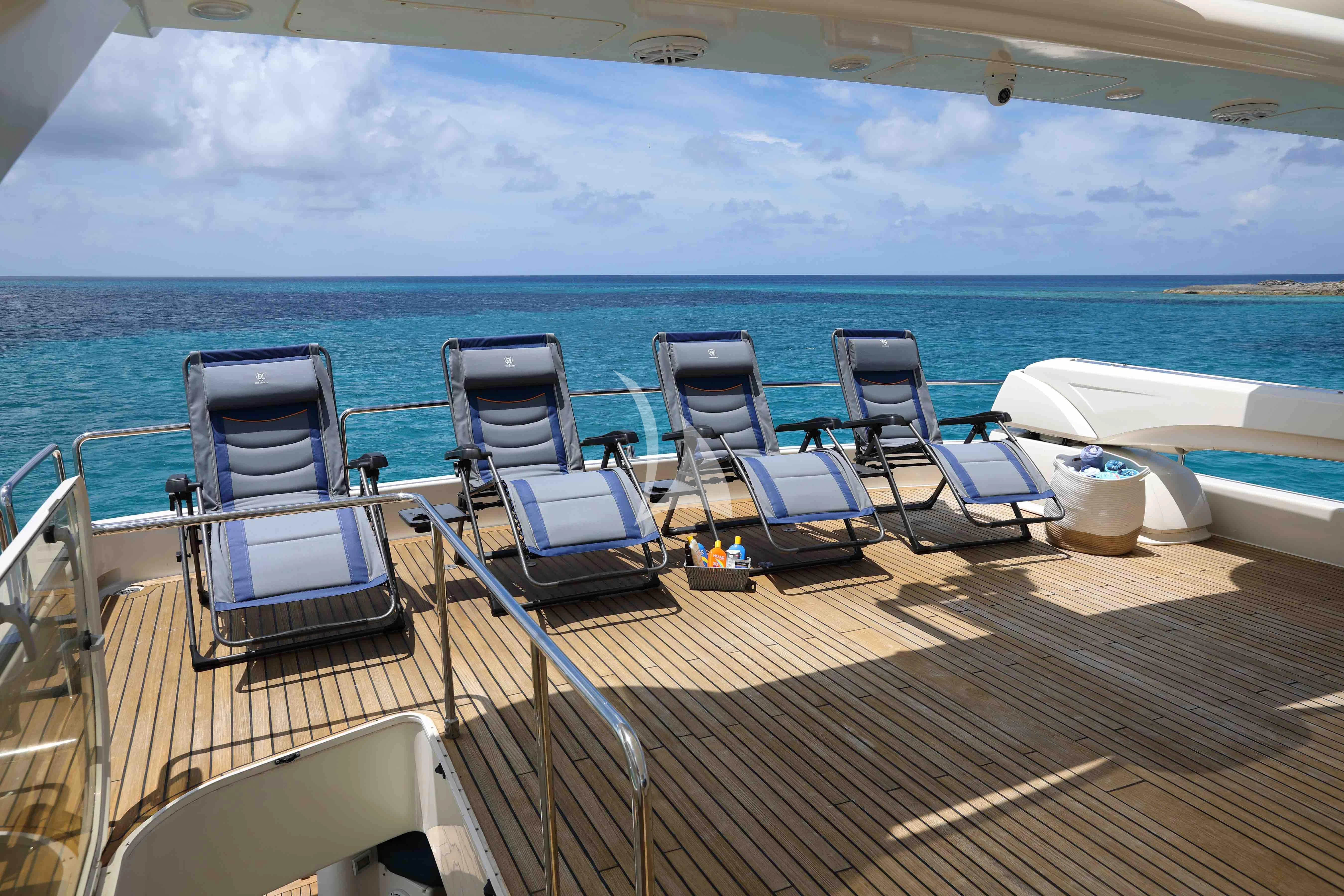 a deck with chairs and tables on it aboard MAMBO Yacht for Sale