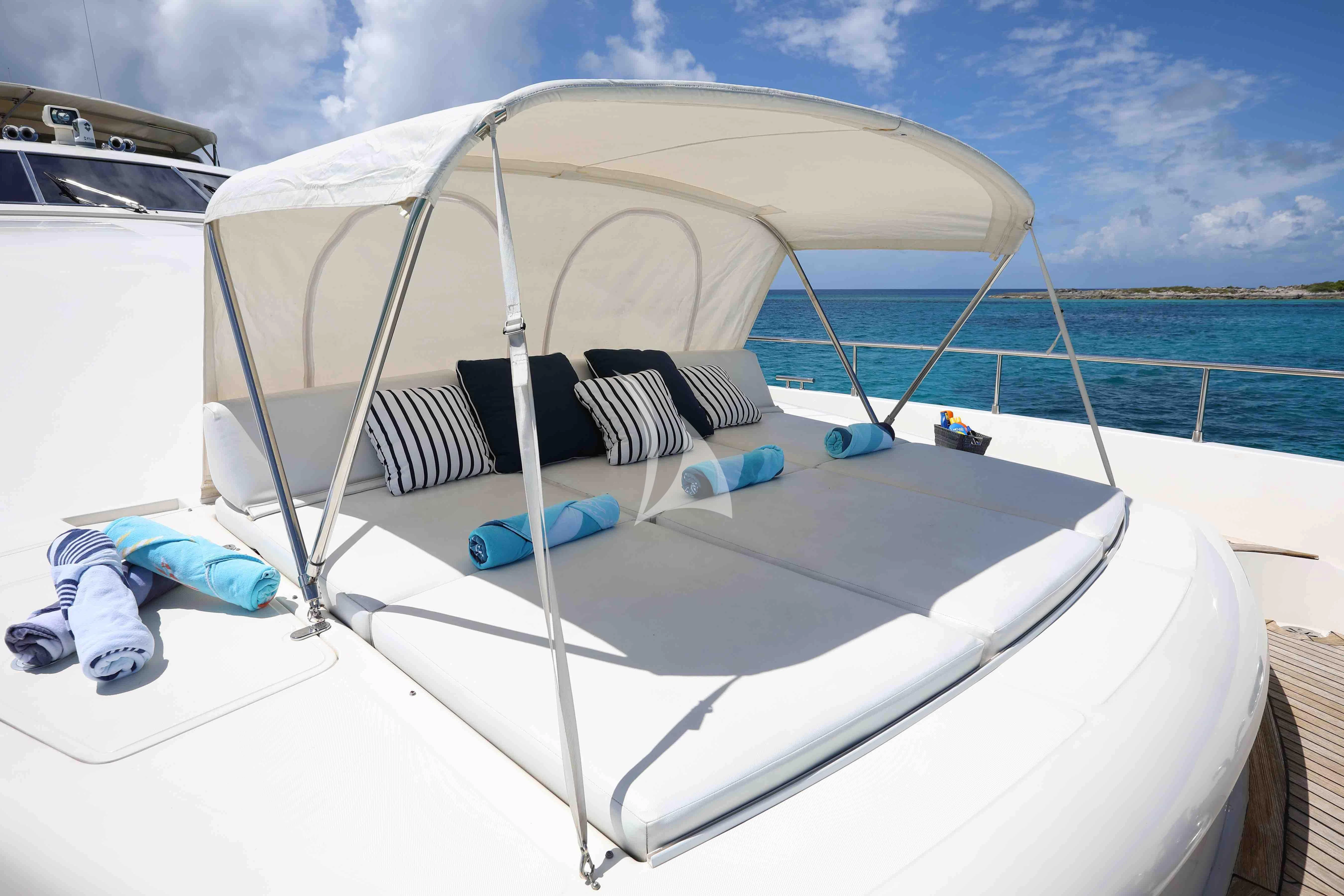 a white boat with a white canopy on a blue day aboard MAMBO Yacht for Sale