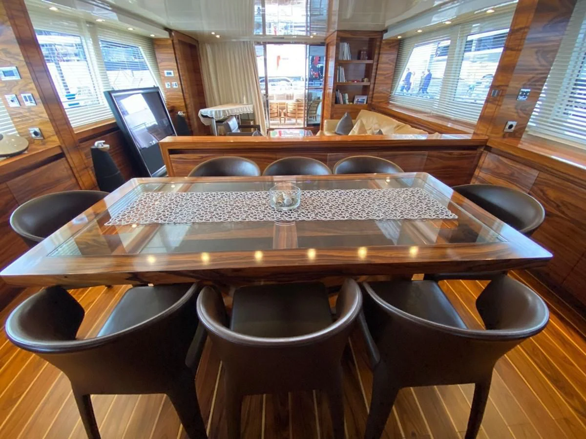 a large wooden table with chairs around it aboard ELAN Yacht for Sale