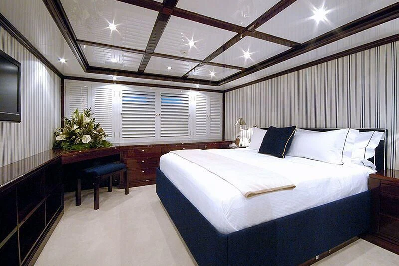 a room with a bed and a television aboard OXYGEN Yacht for Sale