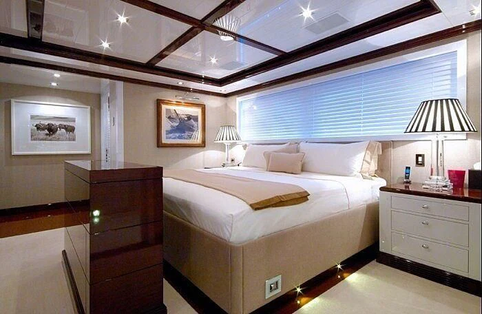 a bedroom with a bed and a lamp aboard OXYGEN Yacht for Sale