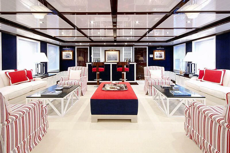a room with a red table and white couches aboard OXYGEN Yacht for Sale